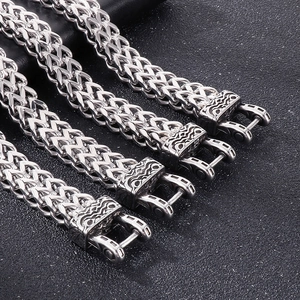 Close-up of four silver wheat-link chains with detailed wave-patterned clasps for men