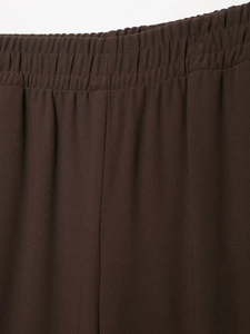 Close-up of elastic high-waist band and premium crepe fabric texture in dark brown