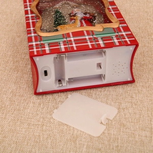 Detail view of the battery compartment and power switch on the bottom of the Christmas music box