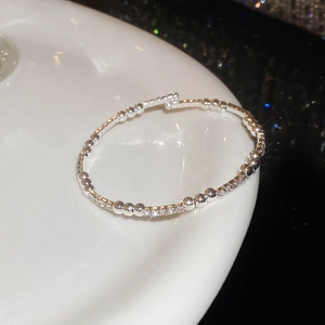 Détail macro du bracelet à billes argentées avec rangées entrelacées serties de diamants