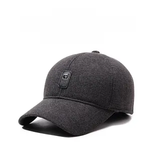 Detailed texture of dark grey winter baseball cap with earflaps and leather logo