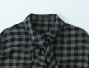 Detailed close-up of the grey plaid shirt featuring a stylish tie-neck ribbon design