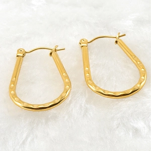 Detail of 18K gold-plated titanium steel U-shaped earrings with unique hammered texture