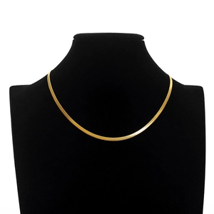 Detailed view of polished 18K gold snake chain on a black velvet necklace bust