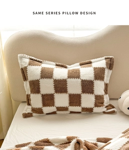 Detail of plush checkered pillow in brown and white with soft fleece texture