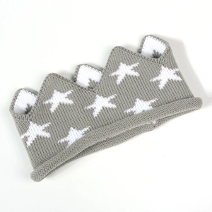 Vue détaillée d'un bandeau couronne en tricot gris pour bébés avec motif d'étoile blanche