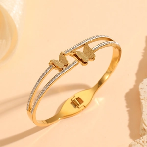 Detail of double-layer gold butterfly bracelet with frosted texture and white crystals