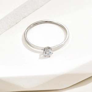 Detail of a minimalist 1mm silver steel ring featuring a classic six-prong solitaire diamond