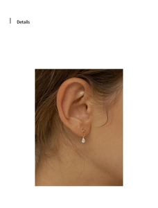 Detail showing 18K gold teardrop earring with pear-cut zircon on link chain