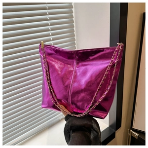 Detail of a purple metallic bucket bag with a stylish woven chain strap in natural light