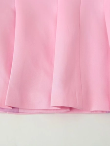 Détail macro de la texture du tissu rose et de l'ourlet plissé du blazer pour femme