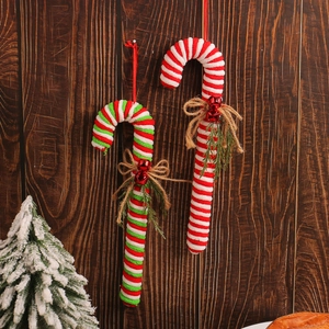 Christmas candy cane hanging ornaments with burlap bows and bells on wood background