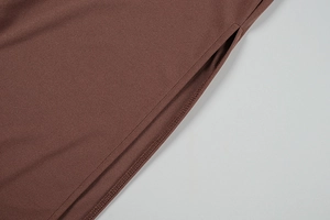 Détail d'une robe en maille marron montrant les coutures et la fente latérale