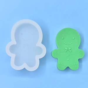 Detail of gingerbread man silicone mold and green soap sample on light blue background