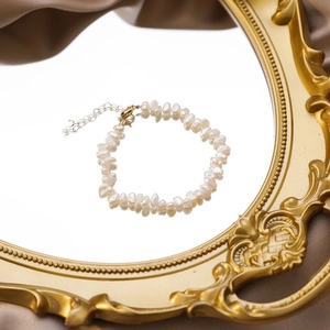 Detailed macro view of baroque freshwater pearls and golden metal clasp on a luxury bracelet