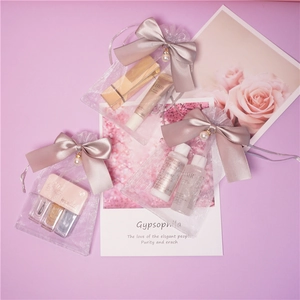 Detail of sheer organza pouches with satin bows and pearl charms for cosmetics