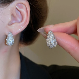 Macro shot of sparkling silver moon teardrop earrings with dense pavé zircon crystals