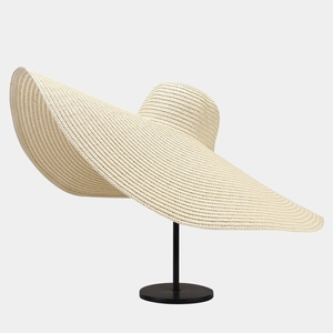 Close-up of the fine straw weave texture and wavy brim of this beige sun hat for women