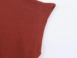 Gros plan sur la maille côtelée fine rouge brique montrant la texture du tissu