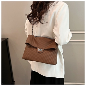 Brown pleated chain shoulder bag with silver clasp shown on a model in a white blazer