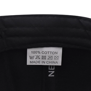 Macro shot of 100% cotton wash label and care symbols inside a black flat brim hat