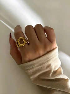 Detail of a gold-plated stainless steel chain ring on hand with red nail polish