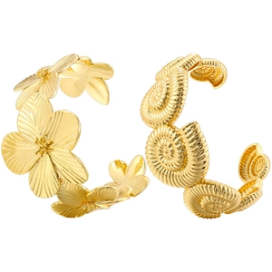 Detailed macro view of golden flower and spiral conch motifs on metal bangles