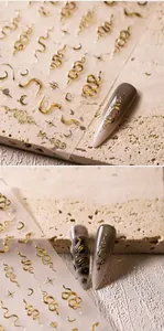 Detail of 3D gold snake nail stickers M-489 with celestial motifs on long pointed nails