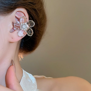 Close-up of crystal flower ear cuff with silver edges and sparkling rhinestones