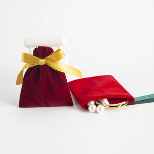 Roter Samt Schmuckbeutel mit Goldband und Perlenarmband, perfekt für Geschenk und Aufbewahrung.