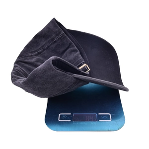 Washed dark gray Dog Mom embroidered baseball cap on digital scale showing 84g weight