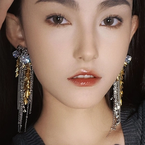 Elegant gold fireworks tassel earrings with sparkling zircon crystals worn by a model