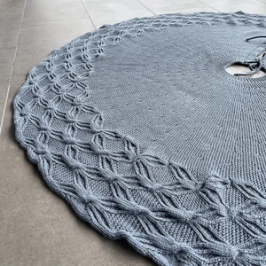 Close-up of greyish-blue knitted Christmas tree skirt with textured diamond pattern
