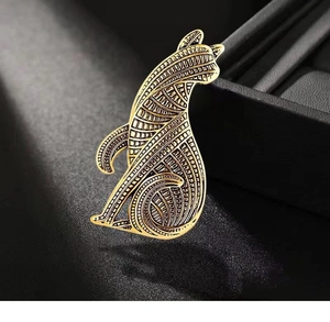 Macro shot of vintage gold cat brooch with intricate geometric engravings and antique finish