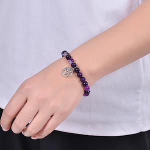 Purple agate beaded bracelet with silver Tree of Life charm worn on a female wrist