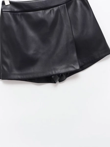 Detalle de falda de cuero PU negro con diseño cruzado y dobladillo con abertura de moda