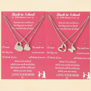 Hollow heart and butterfly mother-daughter necklaces with pink gift cards on a warm background
