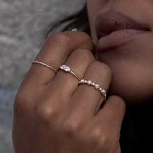 Detail of stacked S925 silver rings with marquise cut gems and pavé diamond bands
