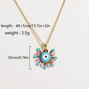 Detail of gold evil eye pendant with blue sunburst, star and moon enamel patterns
