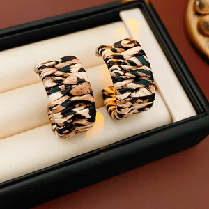 Close-up of leopard print C-shaped leather earrings in a premium jewelry gift box