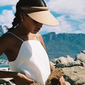 Classic khaki straw open-top sun hat for women shown on a model at a beach resort
