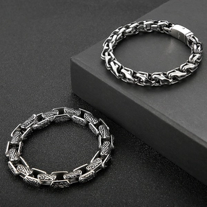 Macro detail of men's vintage titanium steel chain bracelet with totem engraving
