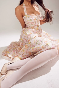 Detail of floral printed maxi dress with ruffled hem paired with beige stiletto heels