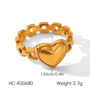 Détail d'une bague coeur doré avec chaîne grillagée creuse et décor perlé