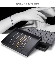 Detail view of dark grey jewelry tray featuring bracelet slots and multi-functional hooks