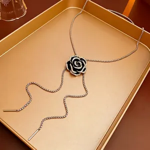Elegant black camellia flower necklace with gold fringe chains and white crystal details