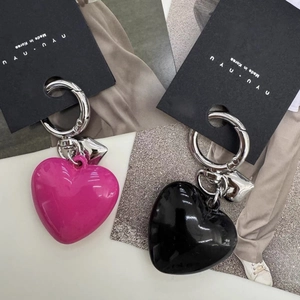 Detailed view of pink and black resin heart keychains with silver metal rings and tags