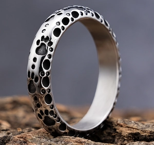 Detailed macro view of punk stainless steel ring with foil texture and cat paw patterns
