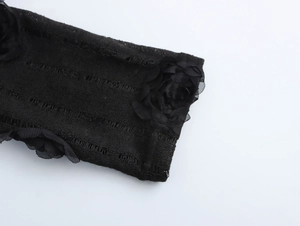 Détail de la rose en mousseline 3D sur manche en maille noire au style gothique
