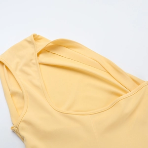 Detail of the asymmetrical neck design and double shoulder straps on the yellow dress